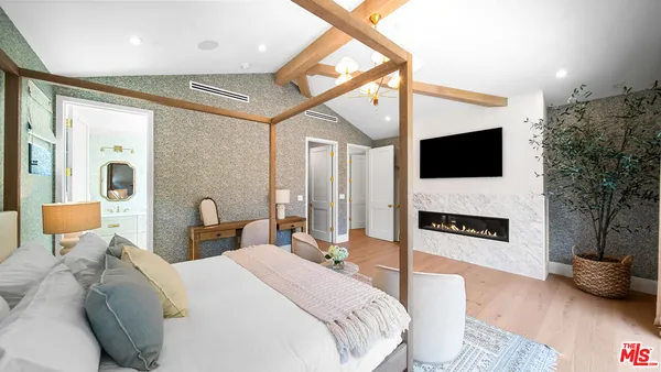 a spacious bedroom with a bed and a flat screen tv