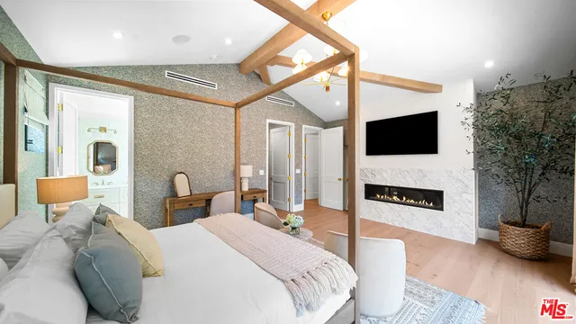 a spacious bedroom with a bed and a flat screen tv