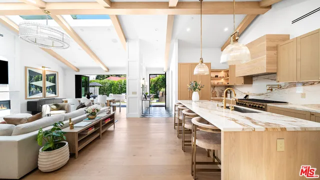 a large kitchen with sink a refrigerator and chairs