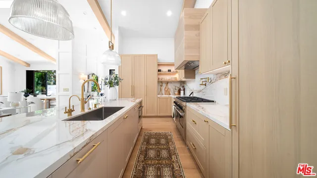 a view of a kitchen with kitchen island a large window a sink and stainless steel appliances