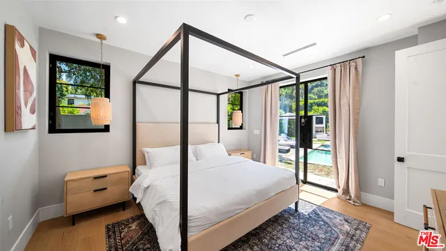 an aerial view of a house with swimming pool and glass top table and chairs