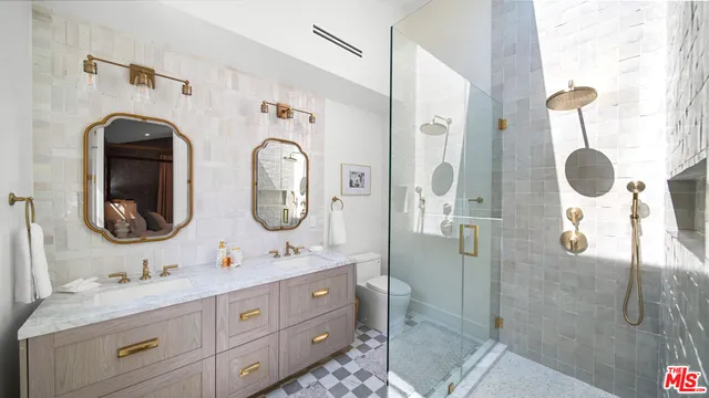 a bathroom with a double vanity sink mirror and shower