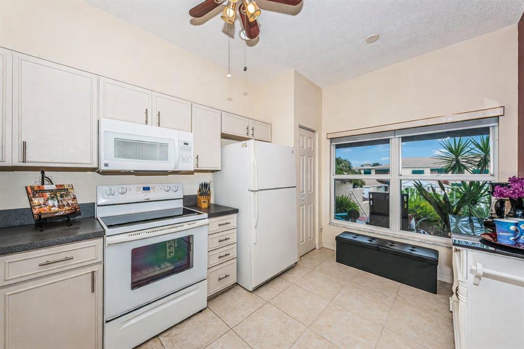6363 99th Way North, Unit 12I St. Petersburg, FL 33708 - Photo 17 of 69 a kitchen with white cabinets and white appliances