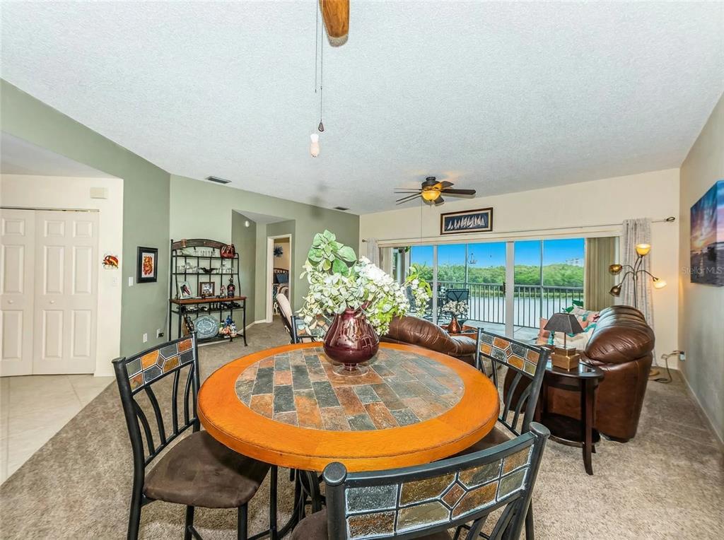 6363 99th Way North, Unit 12I St. Petersburg, FL 33708 - Photo 21 of 69 a dining room with furniture a rug potted plants and wooden floor