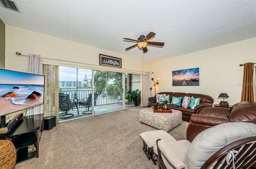 6363 99th Way North, Unit 12I St. Petersburg, FL 33708 - Photo 23 of 69 a living room with furniture ceiling fan and a window