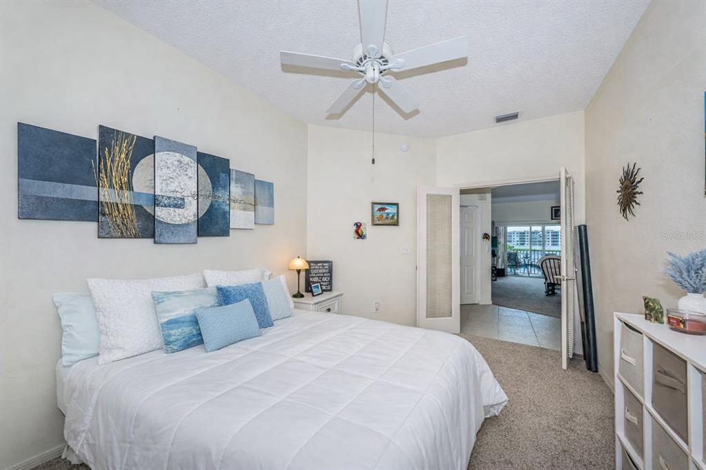 6363 99th Way North, Unit 12I St. Petersburg, FL 33708 - Photo 32 of 69 a bedroom with a large bed and a chandelier