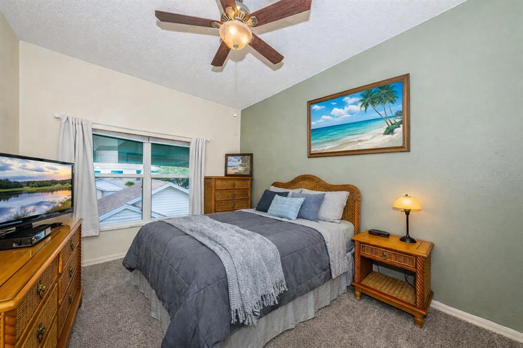 6363 99th Way North, Unit 12I St. Petersburg, FL 33708 - Photo 33 of 69 a spacious bedroom with a bed and a flat screen tv