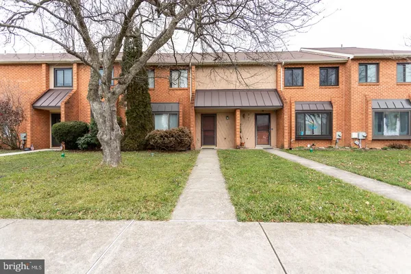 front view of a brick house with a yard