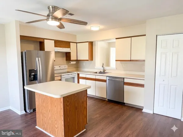 a large kitchen with a wooden floor and stainless steel appliances