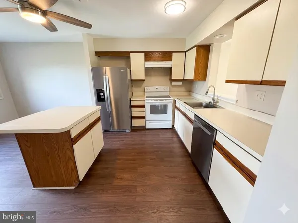 a kitchen with granite countertop white cabinets and wooden floor