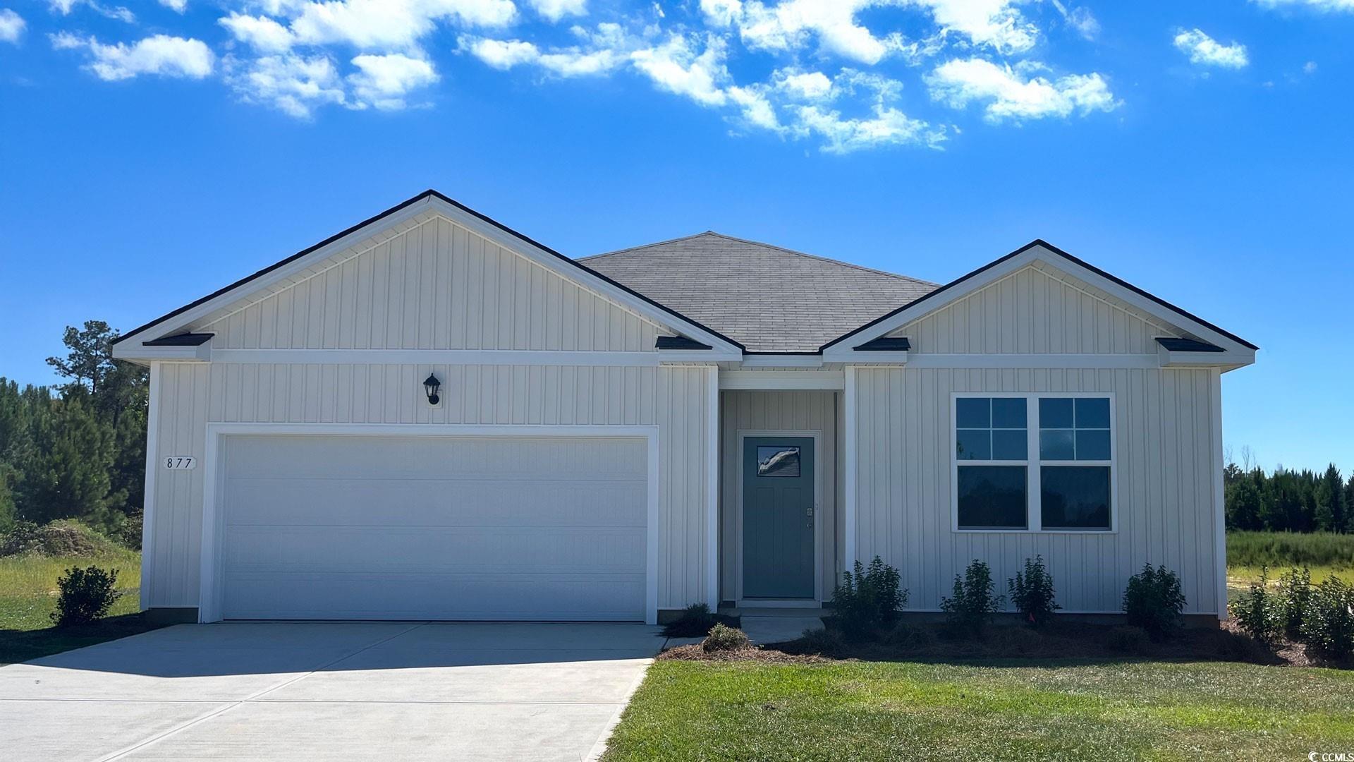 Ranch-style home with an attached garage, concrete driveway, a shingled roof, and a front yard