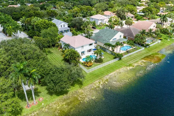 an aerial view of residential houses with outdoor space and trees all around