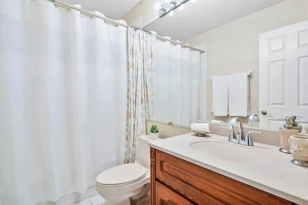 a bathroom with a granite countertop sink a toilet and a mirror