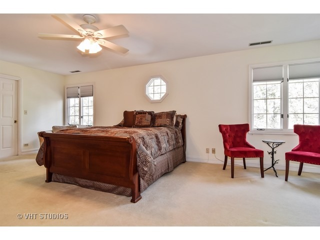 5600 South County Line Road Hinsdale, IL 60521 - Photo 16 of 24 a bedroom with a bed and a chair