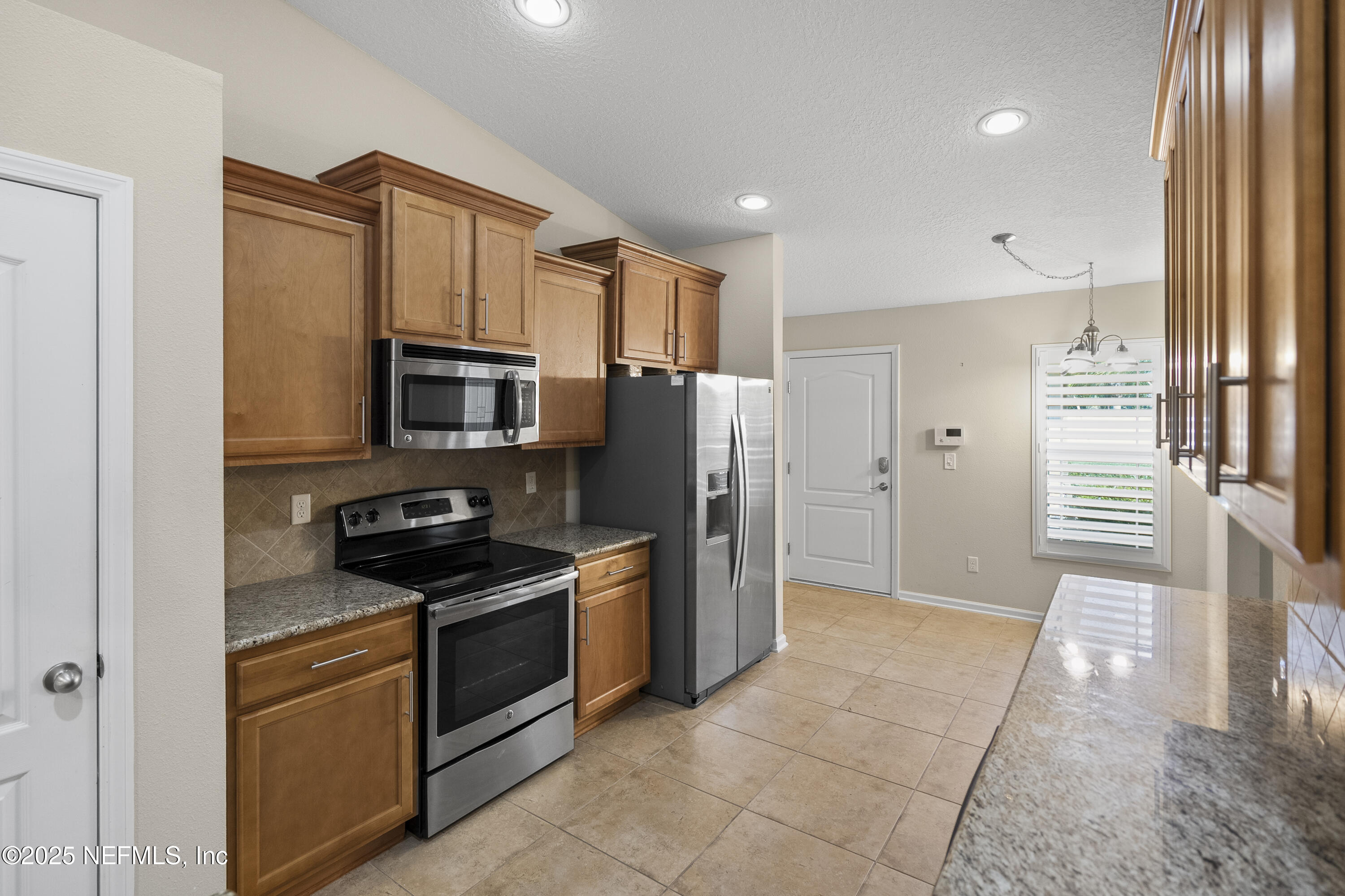 230 Timberwood Drive St. Augustine, FL 32084 - Photo 3 of 34 a kitchen with stainless steel appliances granite countertop a stove a sink and a refrigerator
