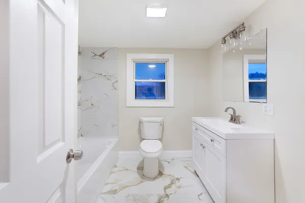 a bathroom with a toilet sink and mirror