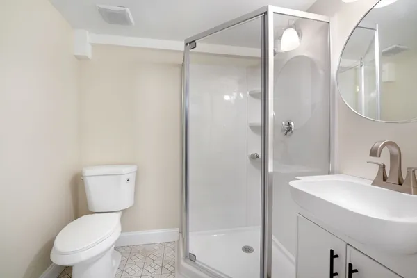 a white toilet sitting next to a bathroom sink