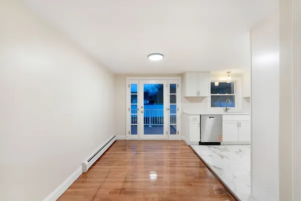 a view of a hallway with a kitchen space and a window
