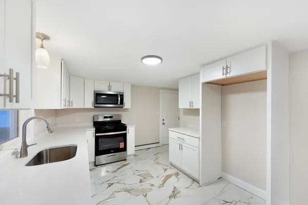 a kitchen with a sink and a stove top oven