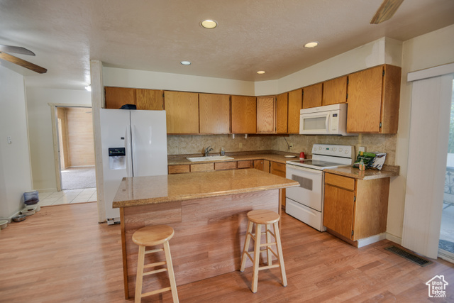2373 East 190 North Beaver, UT 84713 - Photo 28 of 54 Kitchen with a ceiling fan, white appliances, backsplash, a kitchen breakfast bar, and recessed lighting