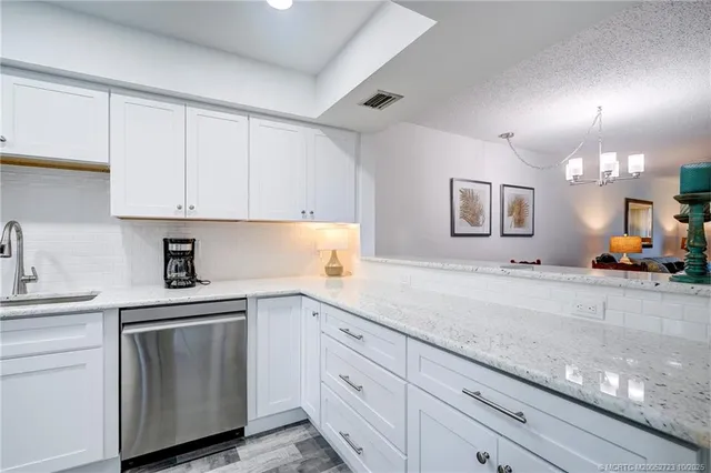 a living room with furniture a chandelier and a dining table