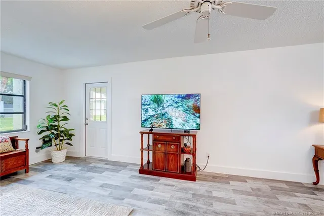 a view of a patio with table and chairs potted plants and palm trees