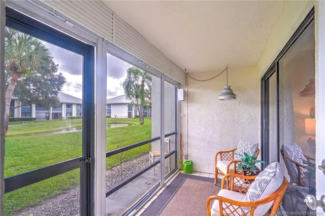 a view of a swimming pool with a yard and palm trees