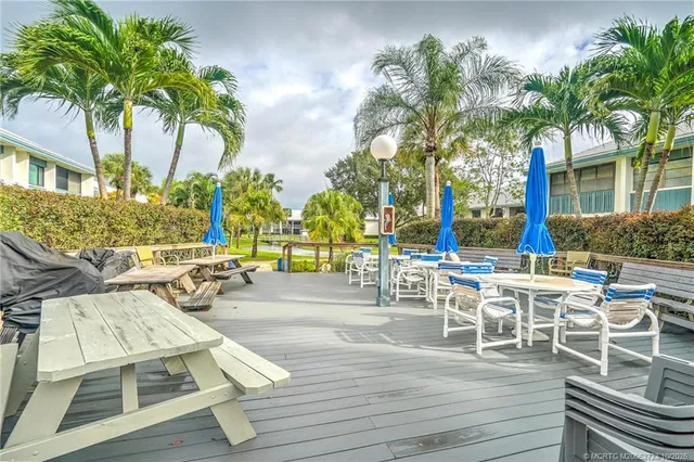 a view of swimming pool with lounge chair and dinning table under an umbrella