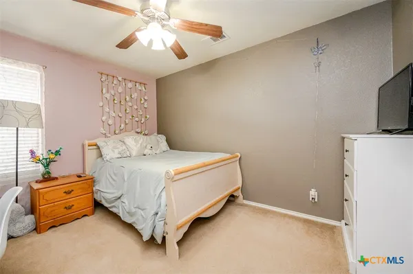 a spacious bedroom with a bed and a chandelier