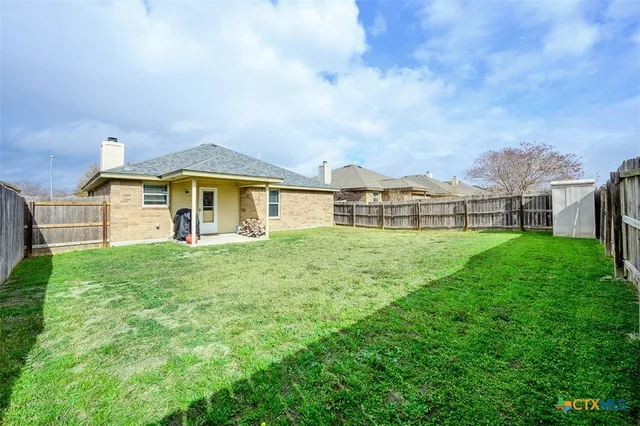 a view of a house with a backyard