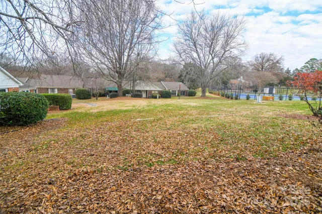 a view of yard with swimming pool and green space