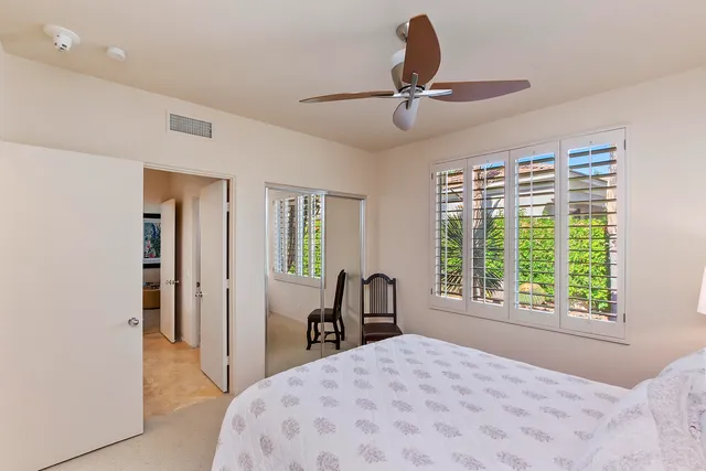 a bedroom with a bed and a large window