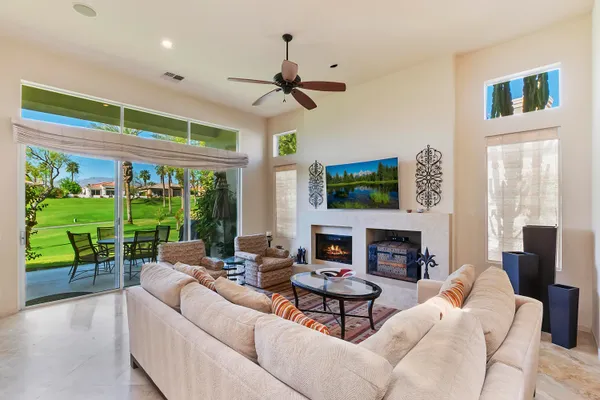 a living room with fireplace furniture and a large window