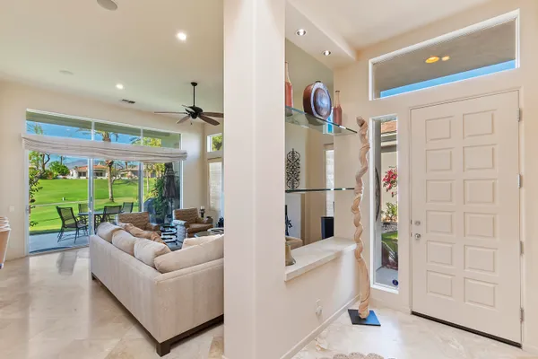 a living room with furniture with a floor to ceiling window and floor to ceiling window