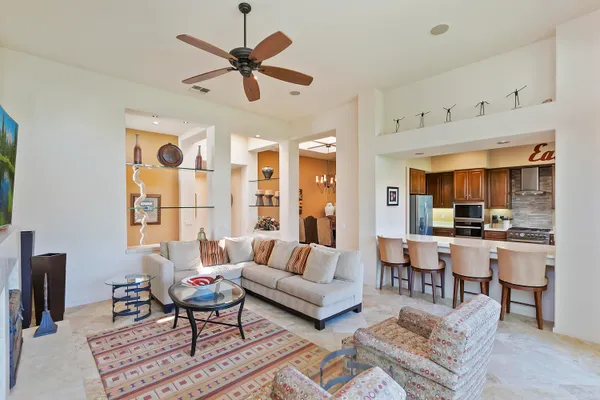 a living room with furniture a ceiling fan and a window