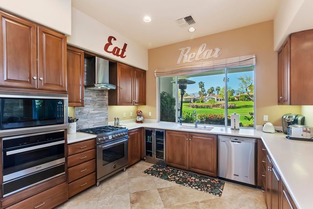 a kitchen with stainless steel appliances a sink dishwasher a stove a microwave oven and a refrigerator