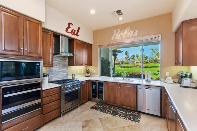 a kitchen with stainless steel appliances a sink dishwasher a stove a microwave oven and a refrigerator