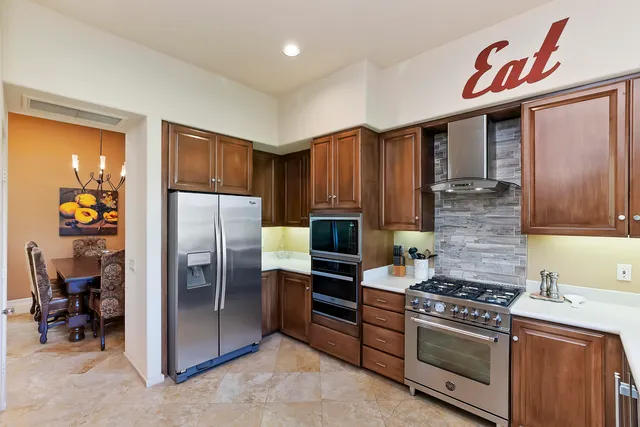 a kitchen with stainless steel appliances granite countertop a refrigerator stove and sink