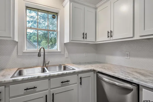 a kitchen with granite countertop white cabinets and a sink