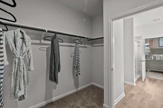 a view of walk in closet with clothes and shoes
