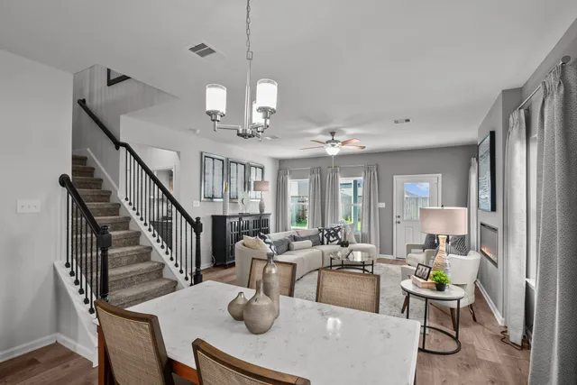 a view of a dining room with furniture a chandelier and wooden floor