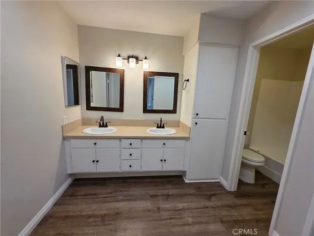 a bathroom with a sink a toilet and mirror