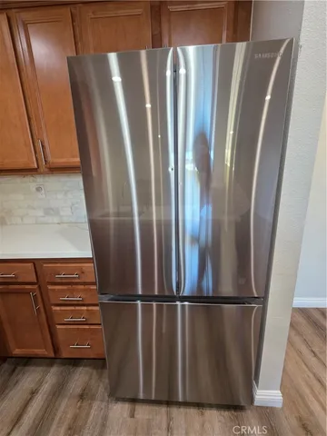 a view of kitchen with stainless steel appliances wooden floor