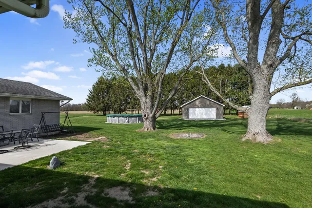 a view of a house with a yard and a bench