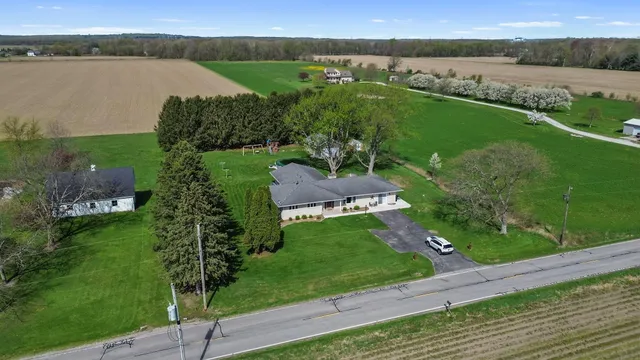 aerial view of a house with a yard and lake view