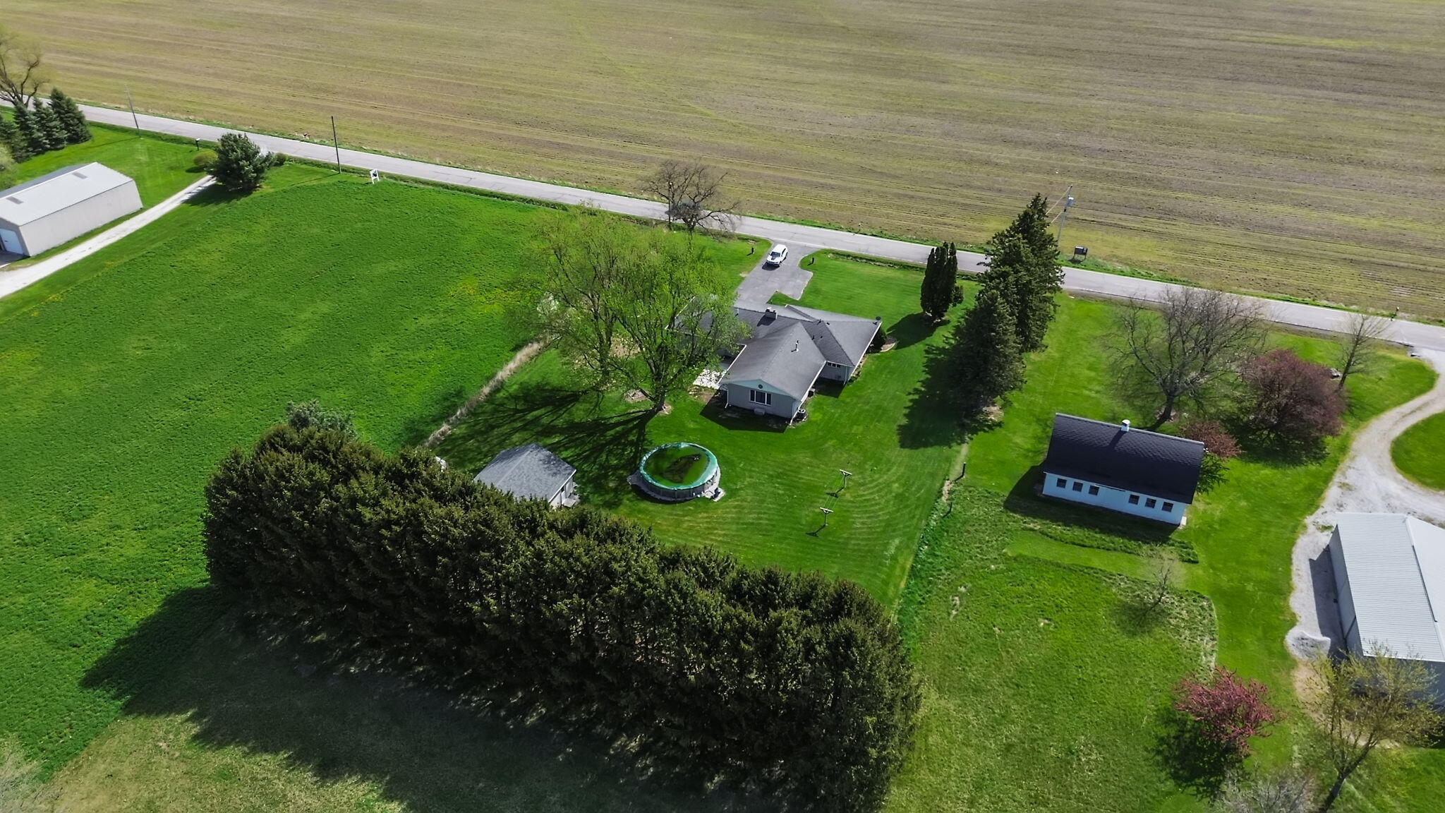 56915 Tulip Road New Carlisle, IN 46552 - Photo 7 of 19 a backyard of a house with lots of green space and plants