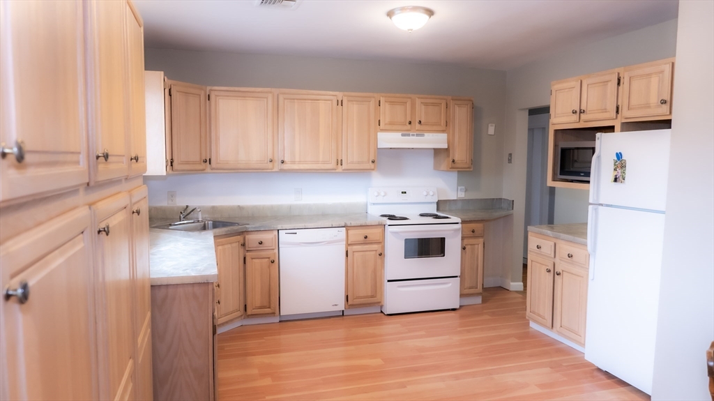 25 Fraser Road Framingham, MA 01702 - Photo 2 of 21 a kitchen with a white stove top oven and white stainless steel appliances