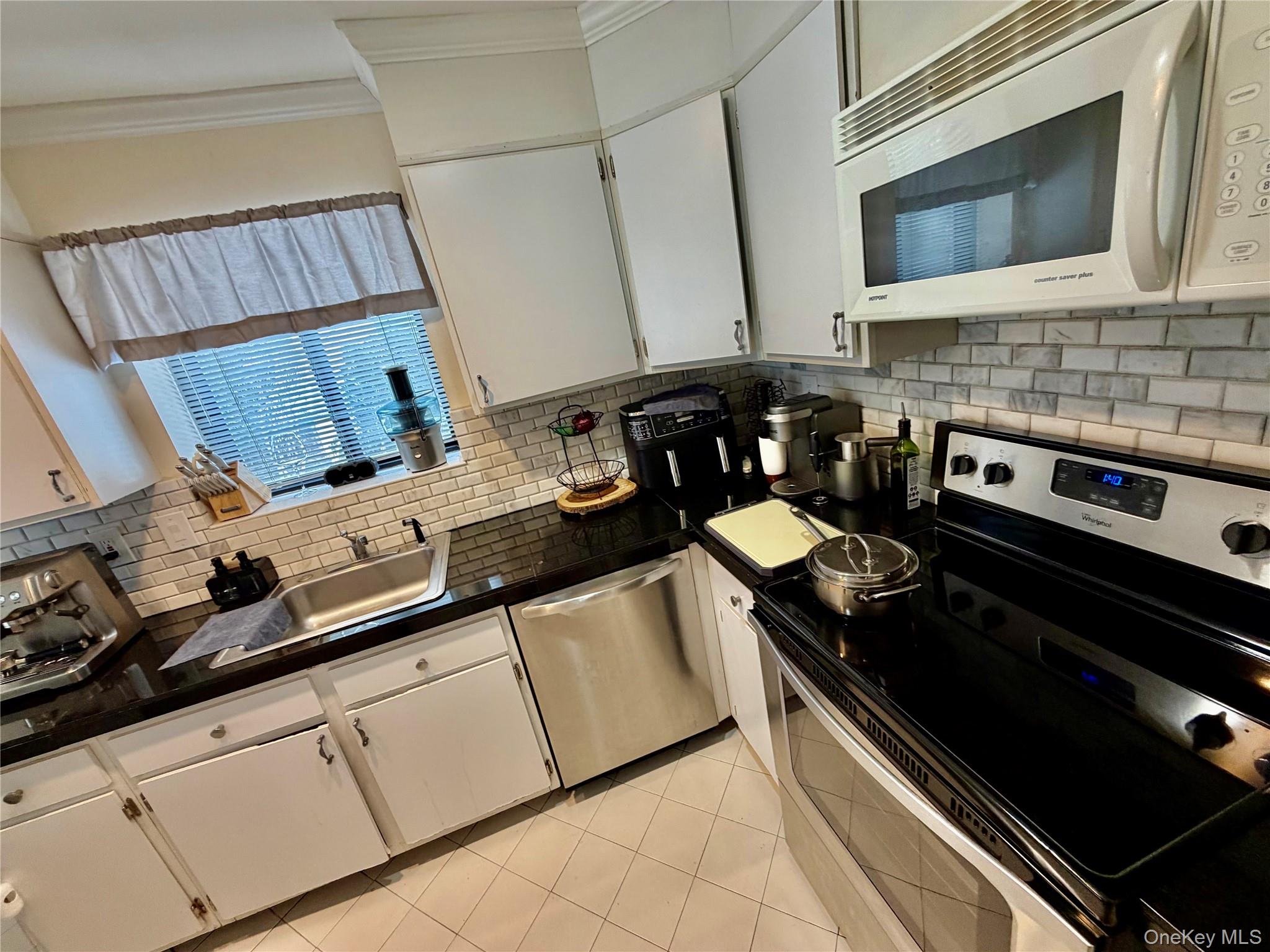 75 Greenway Close, Unit 1 Rye Brook, NY 10573 - Photo 22 of 24 a kitchen with granite countertop a stove and a sink