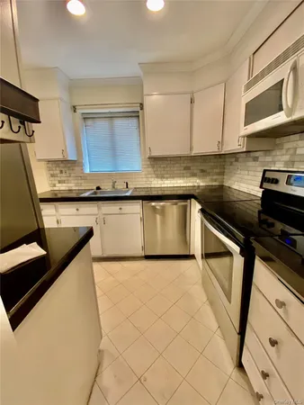 a kitchen with granite countertop a sink stove and cabinets