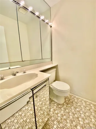 a bathroom with a sink a toilet and a mirror